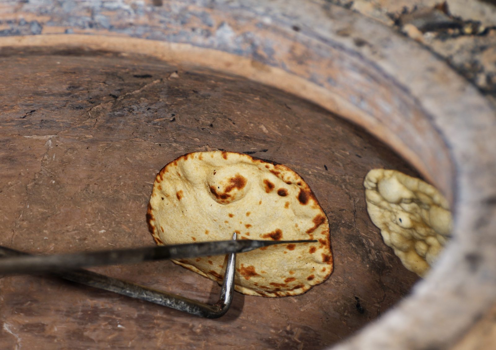 Naan cuit au four tandoor traditionnel dans la cuisine du restaurant ZAFRAN à Avignon